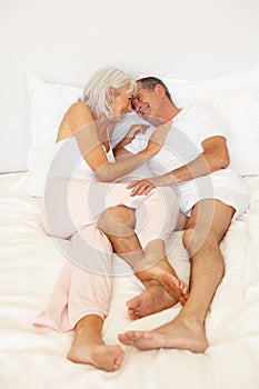 Senior Couple Relaxing On Bed