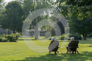 Senior couple relaxing in chairs on a sunny garden lawn
