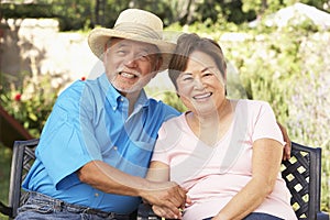 Senior Couple Relaxing In Garden Together