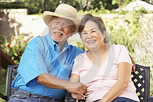 Senior Couple Relaxing In Garden Together