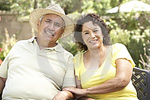 Senior Couple Relaxing In Garden Together