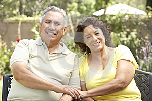 Senior Couple Relaxing In Garden Together