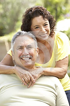 Senior Couple Relaxing In Garden Together