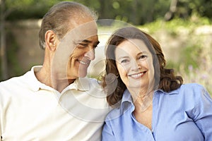 Senior Couple Relaxing In Garden Together