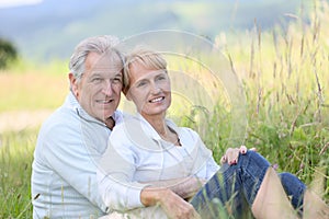 Senior couple relaxing in grass