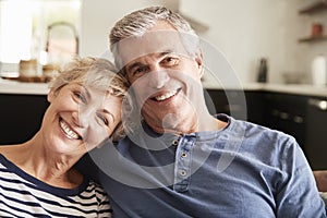Senior couple relaxing at home smiling to camera, close up