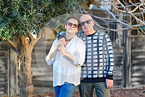 Senior couple relaxing by the park on sunny day.