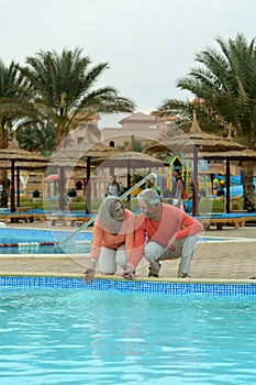 Senior couple relaxing at pool at hotel resort