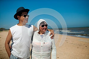 Senior couple relaxing by the sea on sunny day