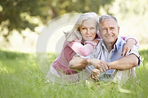 Senior Couple Relaxing In Sunny Summer Field