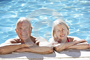 Senior Couple Relaxing In Swimming Pool Together