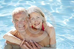 Senior Couple Relaxing In Swimming Pool Together