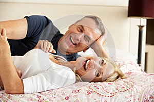 Senior Couple Relaxing Together In Bed