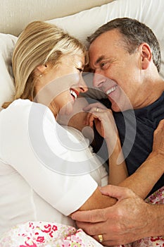 Senior Couple Relaxing Together In Bed