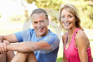 Senior Couple Resting After Exercising In Park
