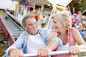 Senior couple on a ride in amusement park