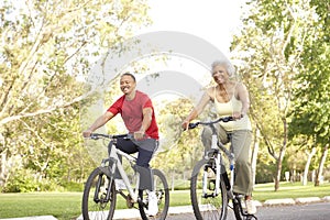 Senior Couple Riding Bikes In Park photo