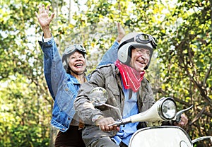 Senior couple riding a classic scooter