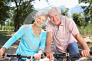 Senior couple riding through countryside