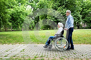 Senior couple rolling and strolling in the park