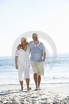 Senior Couple Running Along Beach