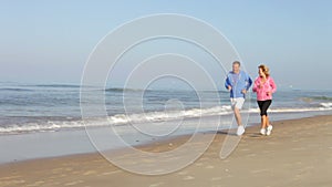 Senior Couple Running On Empty Beach
