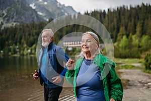 Senior couple running by the lake in the mountains.