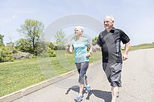 Senior couple running in park