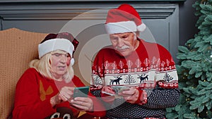 Happy senior family on mobile phone buy Christmas presents doing online ecommerce shopping purchase