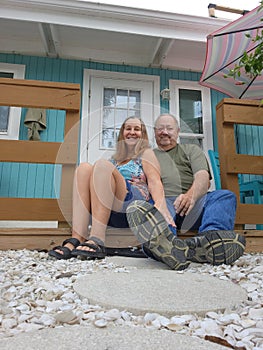 Senior couple sat on house porch