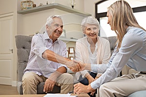 Senior couple shaking hands with financial advisor