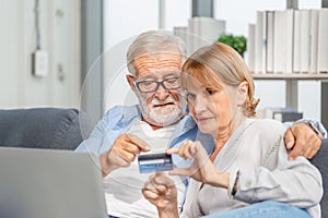 Senior couple shopping online in living room, Elderly man and woman using computer laptop on cozy sofa at home, Happy family