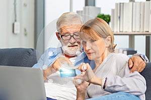 Senior couple shopping online in living room, Elderly man and woman using computer laptop on cozy sofa at home, Happy family