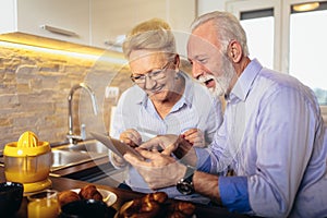 Senior couple shopping online with tablet and credit card