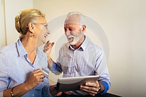 Senior couple shopping online with tablet and credit card