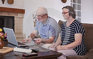 Senior couple shopping online using credit card on laptop