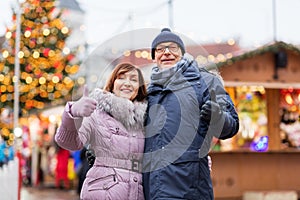 Senior couple shows thumbs up at christmas market