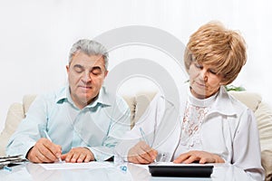 Senior couple sign up document sitting sofa