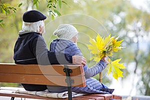 Senior couple sitting on bench in park