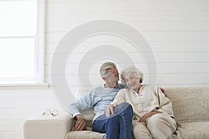 Senior couple sitting on couch smiling portrait