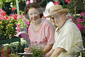 Senior Couple sitting among flowers