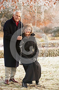 Senior Couple Sitting On Garden Swing