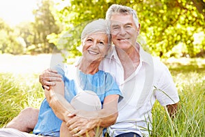 Senior couple sitting on grass together relaxing