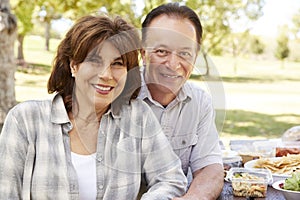 Senior couple sitting at picnic table in a park