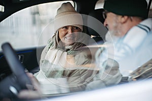 Senior couple sitting in their electric car.