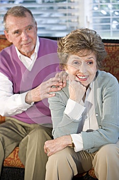 Senior couple sitting together, focus on woman