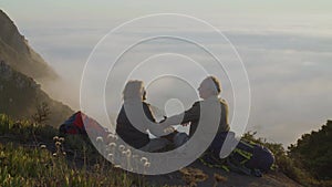 Senior couple sitting on top of mountain and enjoying view