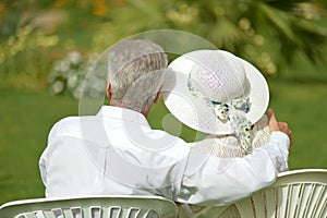 Senior couple sitting at tropic hotel garden