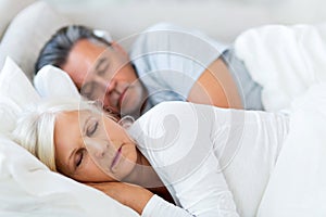 Senior couple sleeping in bed