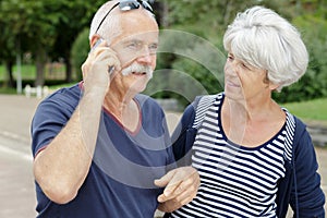 Senior couple with smartphone outside